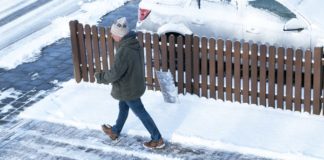 Mann läuft über schneefreie Einfahrt