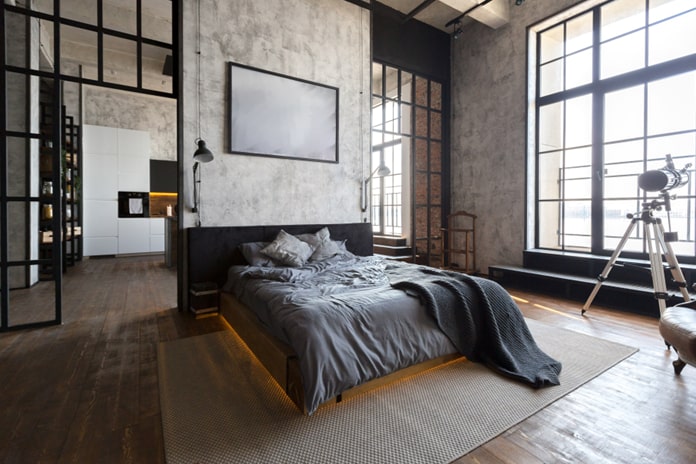 Schlafzimmer mit Bett, Betonwände und Fenster aus Stahl
